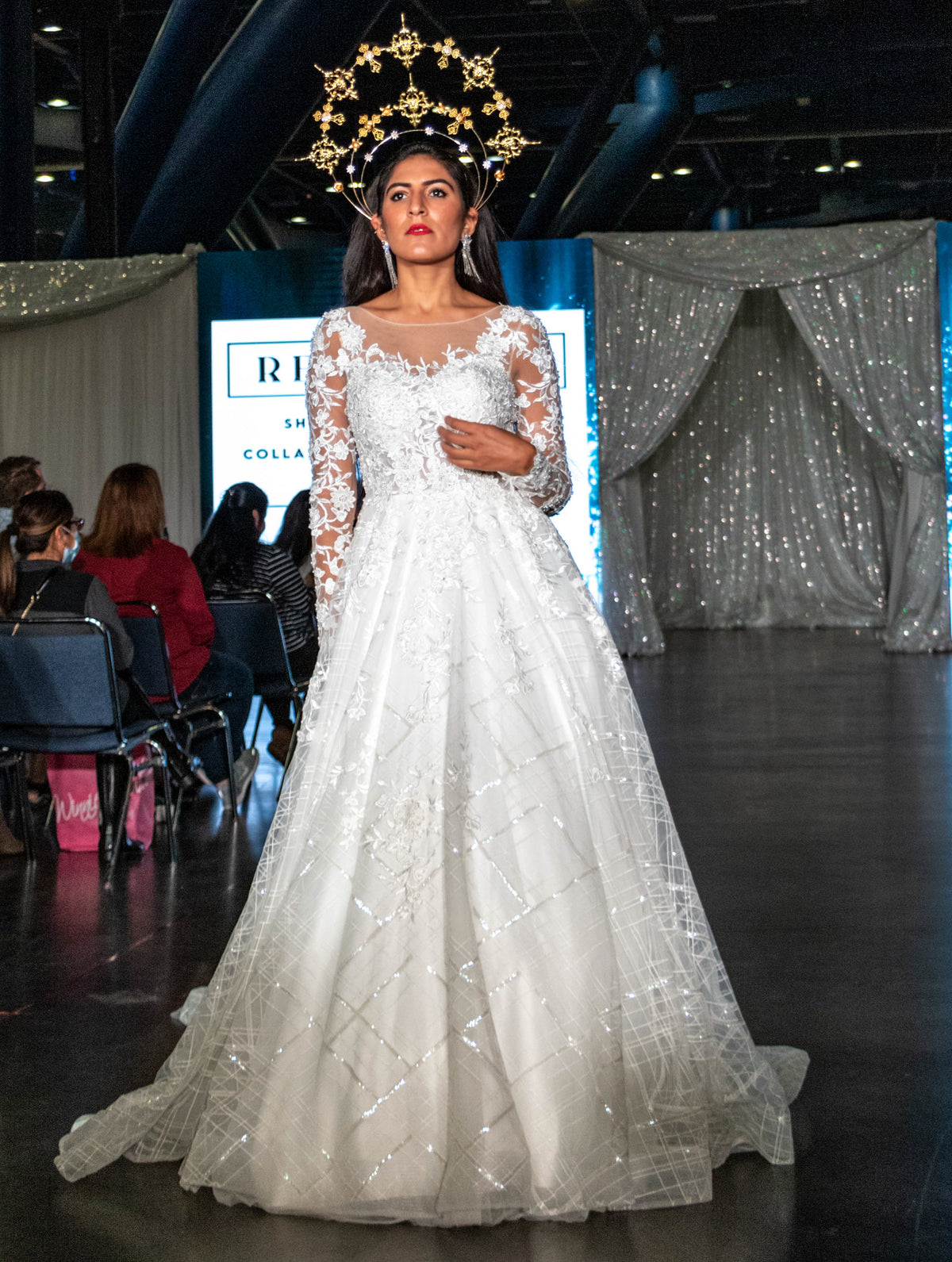Bride in custom lace wedding gown with gold crown on runway, Houston bridal fashion show