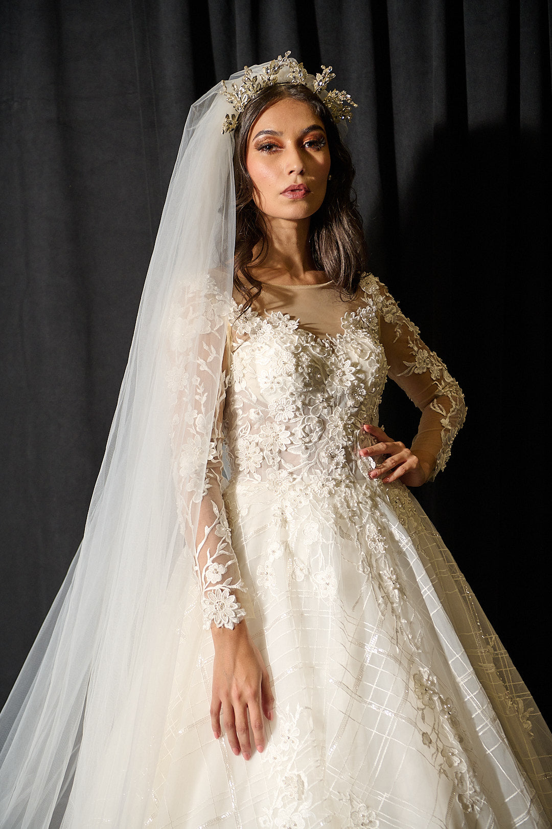 Bride in custom lace wedding gown with long sleeves, veil, and floral crown, Houston bridal design