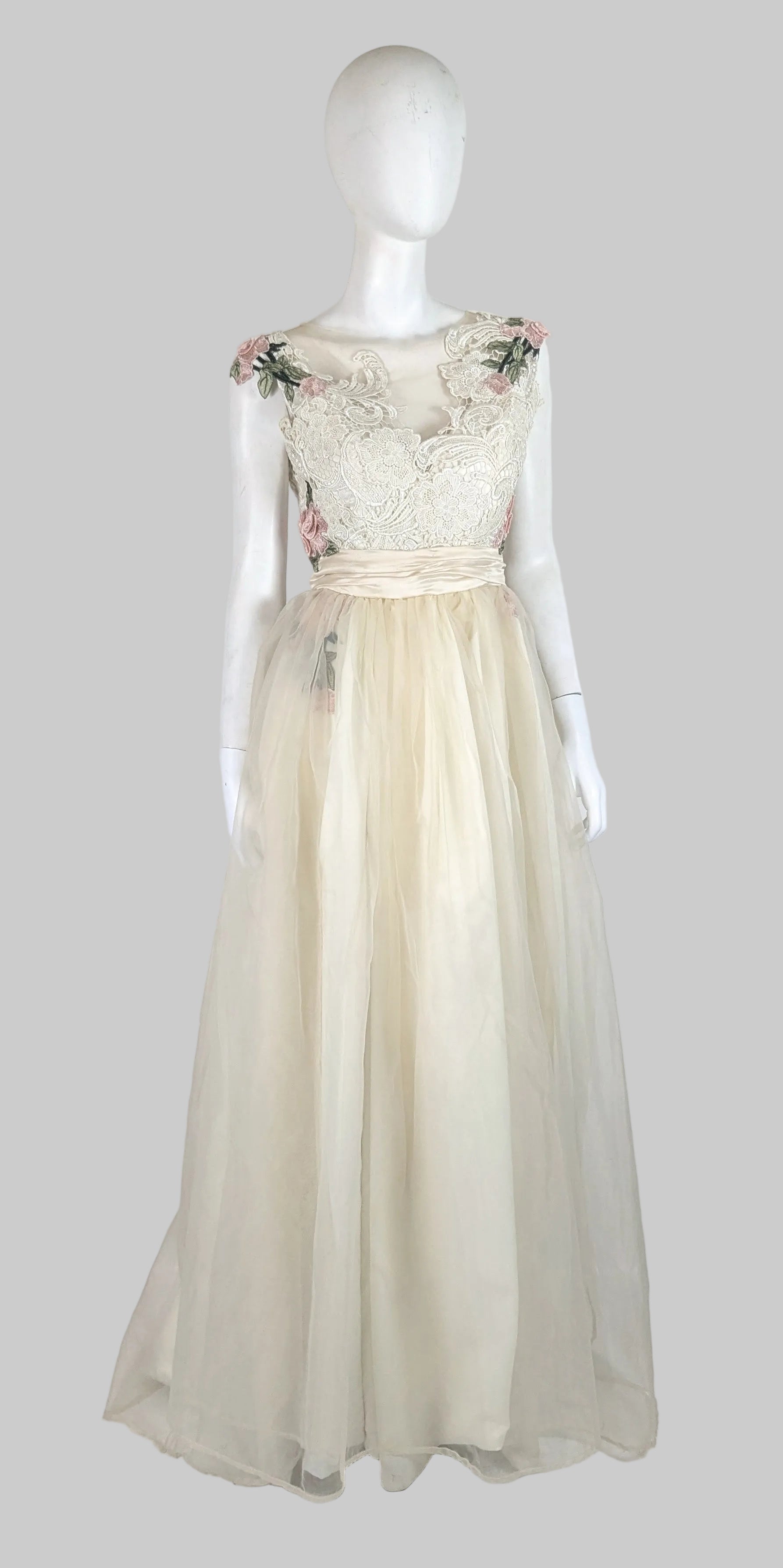 Mannequin wearing a floral lace top and beige skirt on a white background