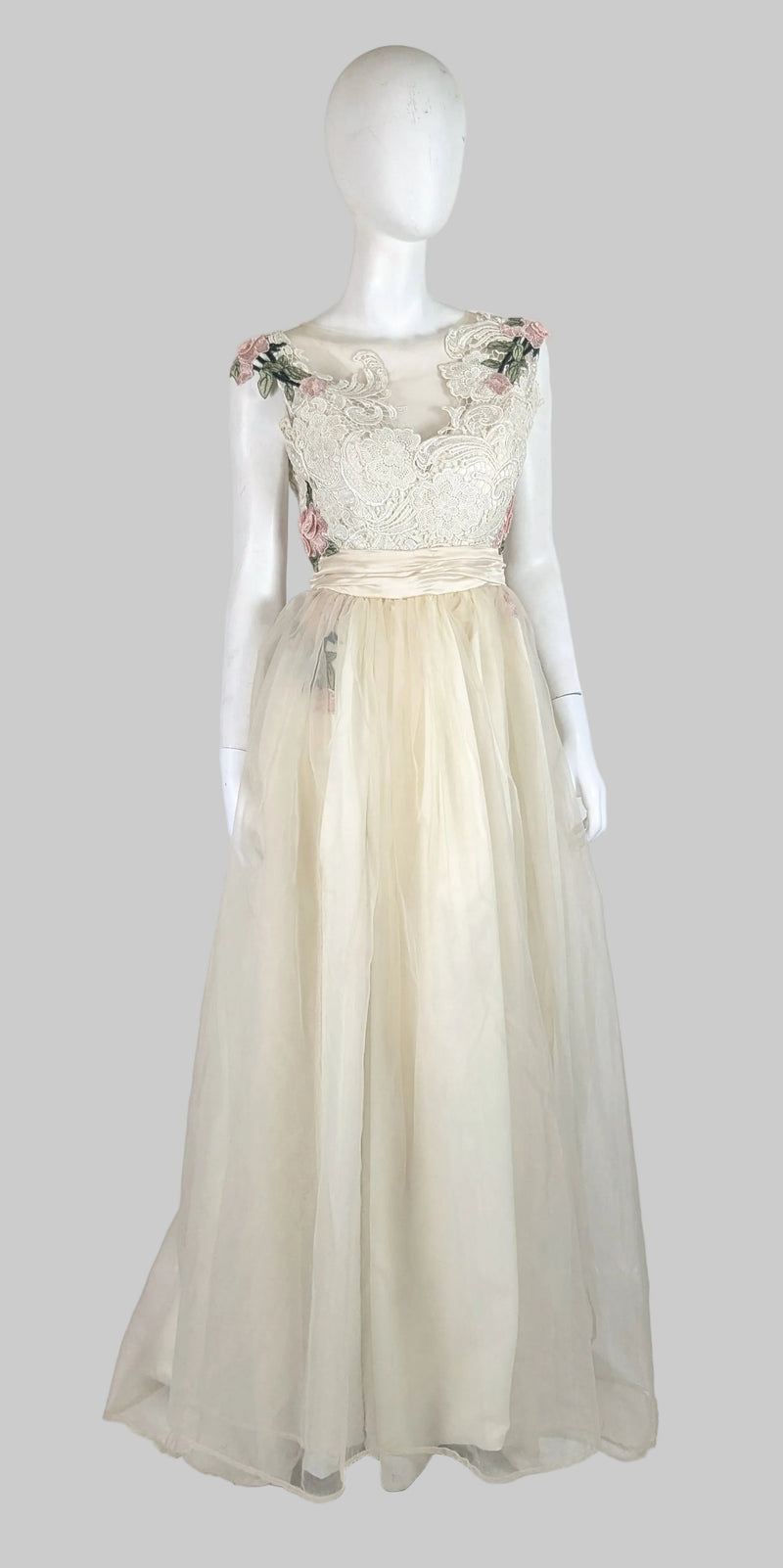 Mannequin wearing a floral lace top and beige skirt on a white background