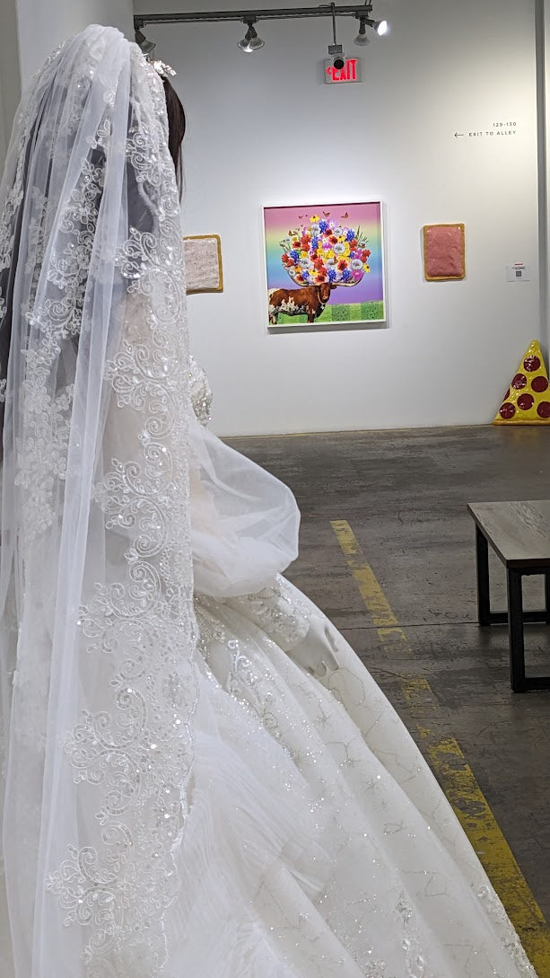 Bride in custom lace wedding gown with long veil, art gallery backdrop, Houston bridal design