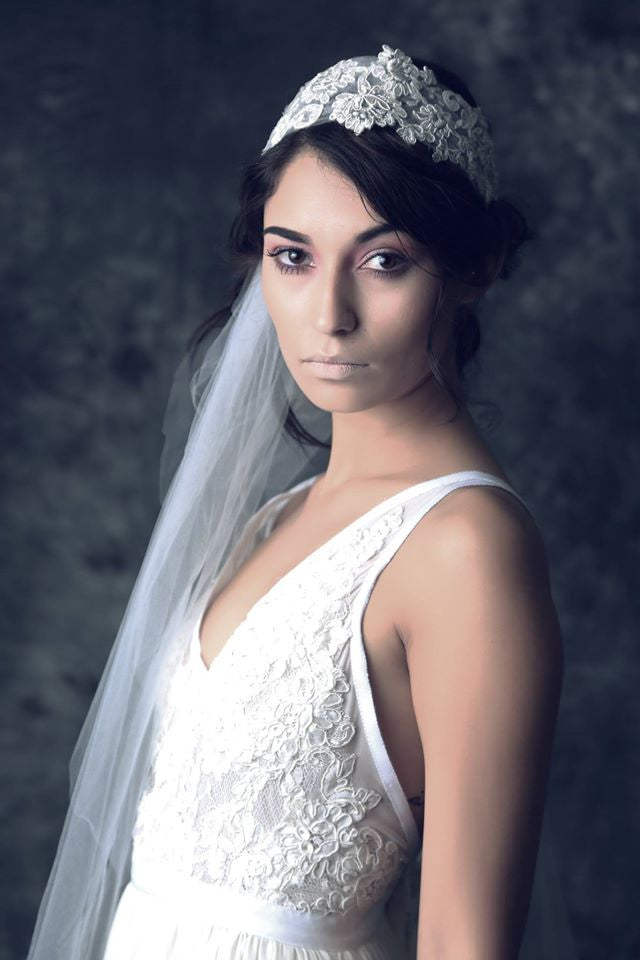 Bride in lace wedding dress with floral headpiece and veil, elegant bridal style