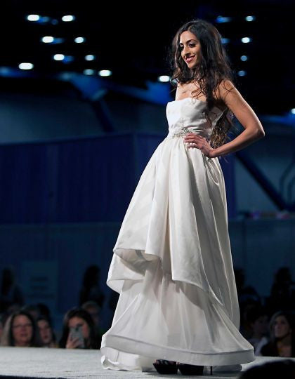 Elegant strapless wedding dress with layered skirt on runway