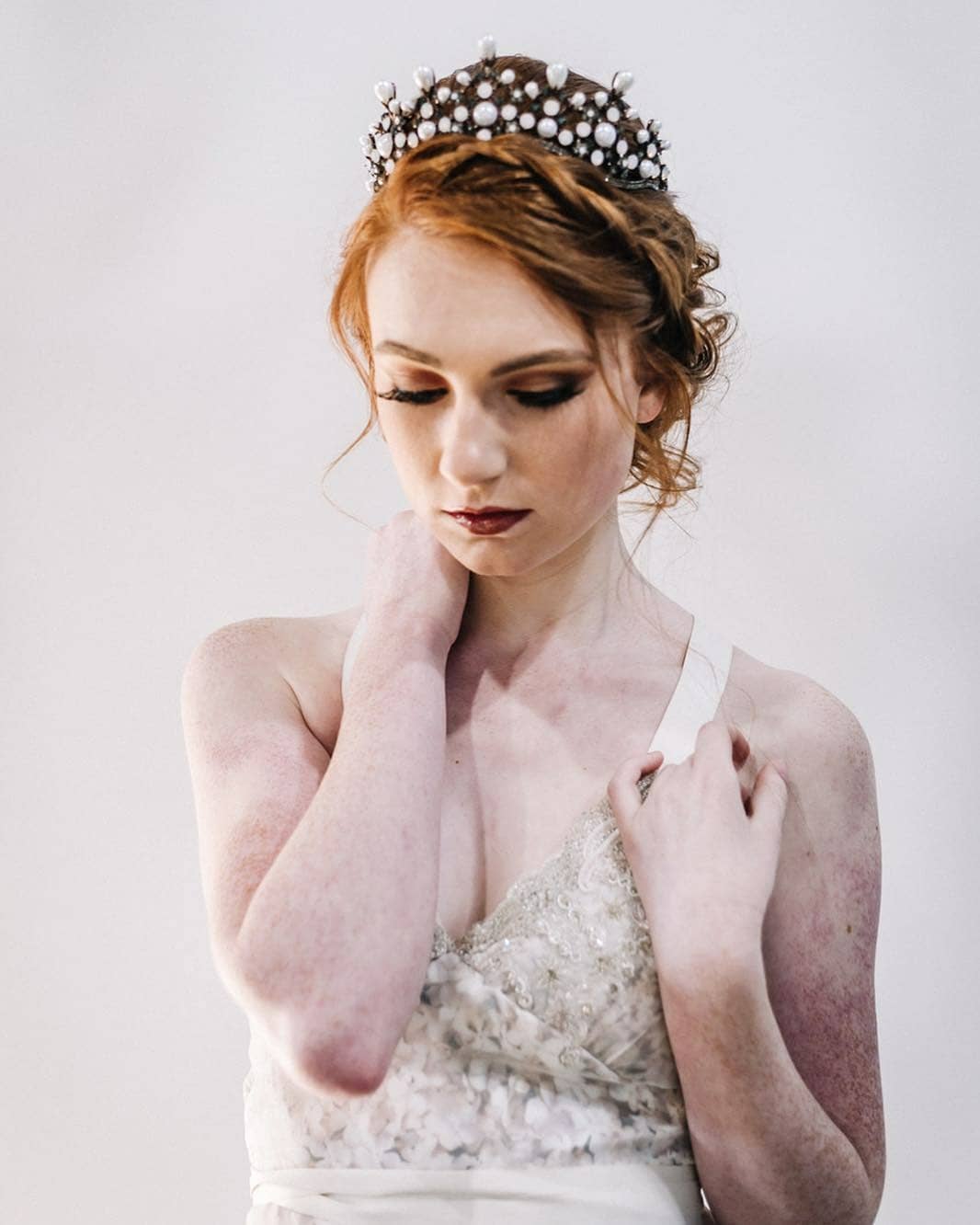 Bride in custom lace wedding dress with pearl crown, embracing inclusive bridal style for all bodies