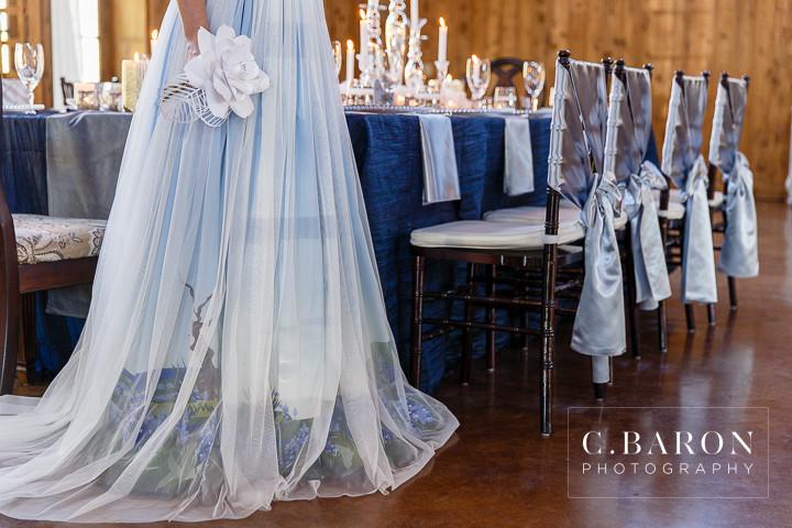 Custom ombre wedding dress with floral detail, set in elegant reception venue with draped chairs