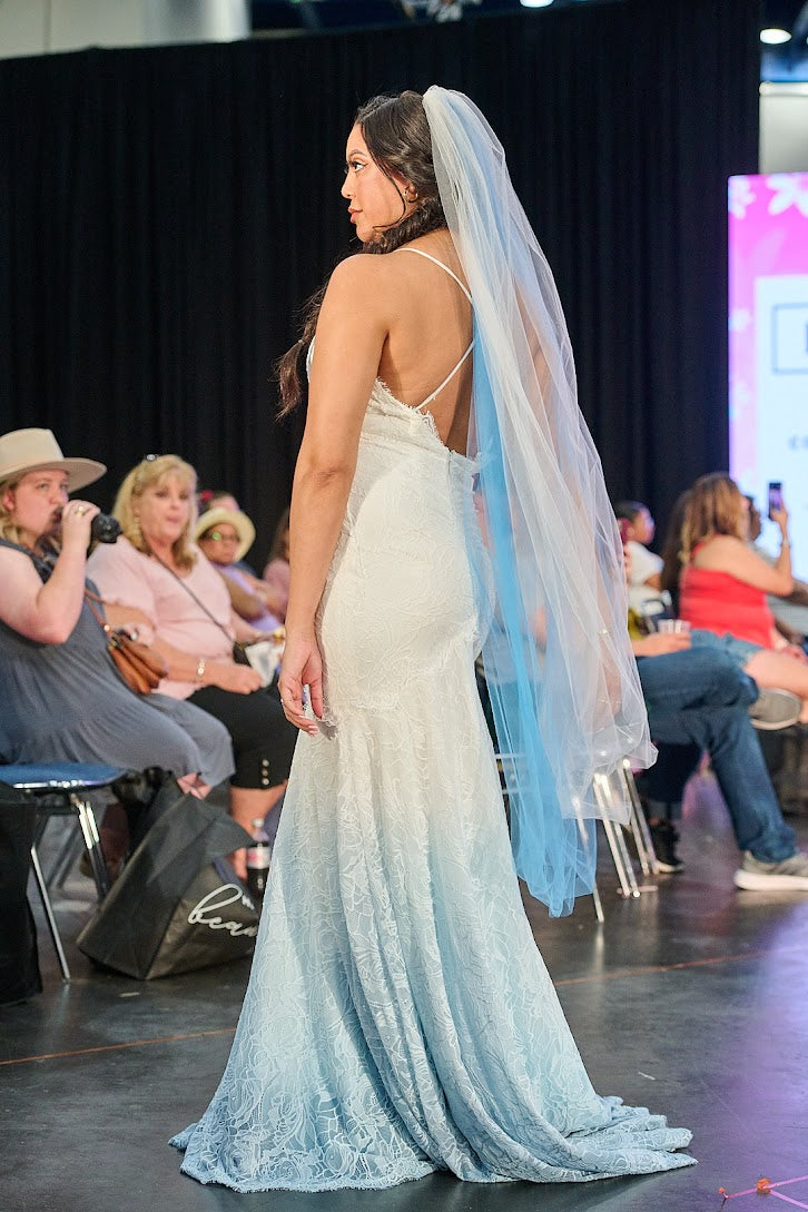 Bride in ombre lace wedding dress with blue veil at runway show