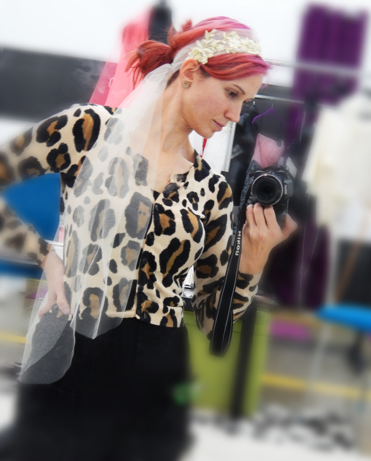 Bride in leopard print cardigan with veil, capturing a moment with a camera