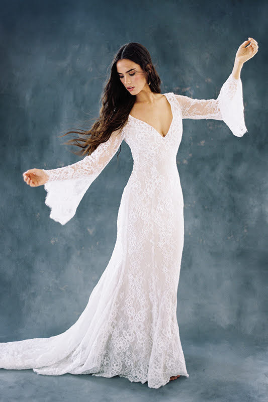 Elegant lace wedding dress with bell sleeves and deep V-neck, perfect for boho bridal style.