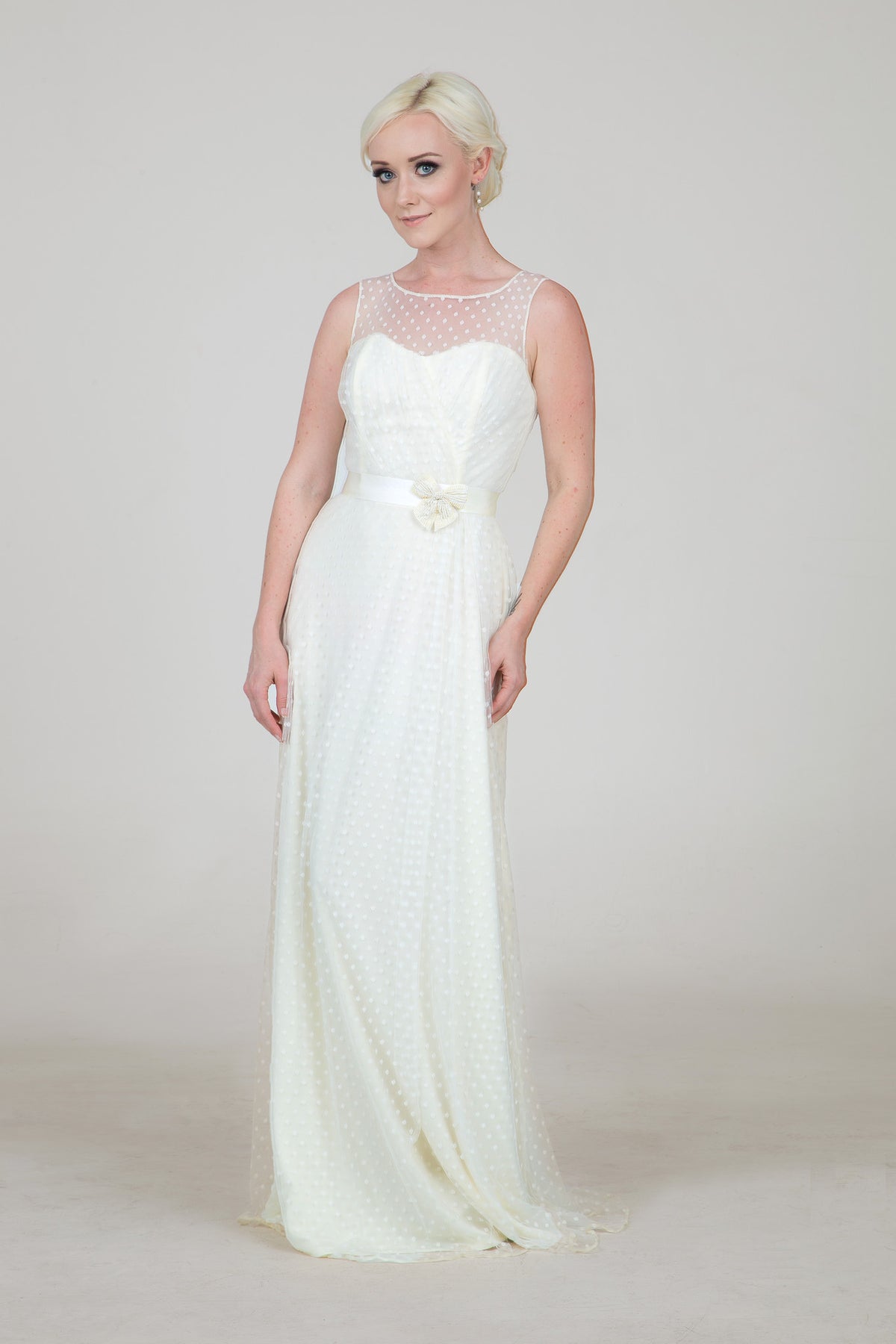 Elegant white polka dot wedding dress with sheer overlay and bow belt