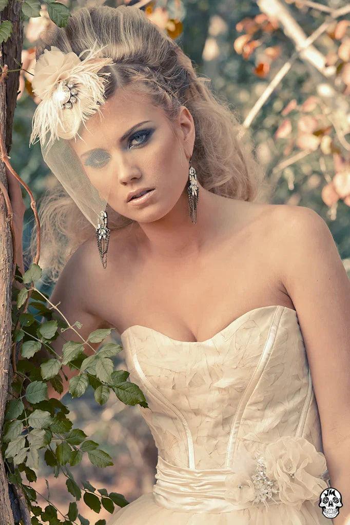 Elegant strapless wedding dress with floral details, feathered headpiece, and vintage-inspired accessories