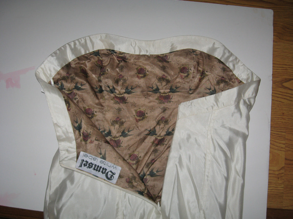 Custom bridal dress with floral and swallow print lining, white satin exterior, and 'White Label' tag.