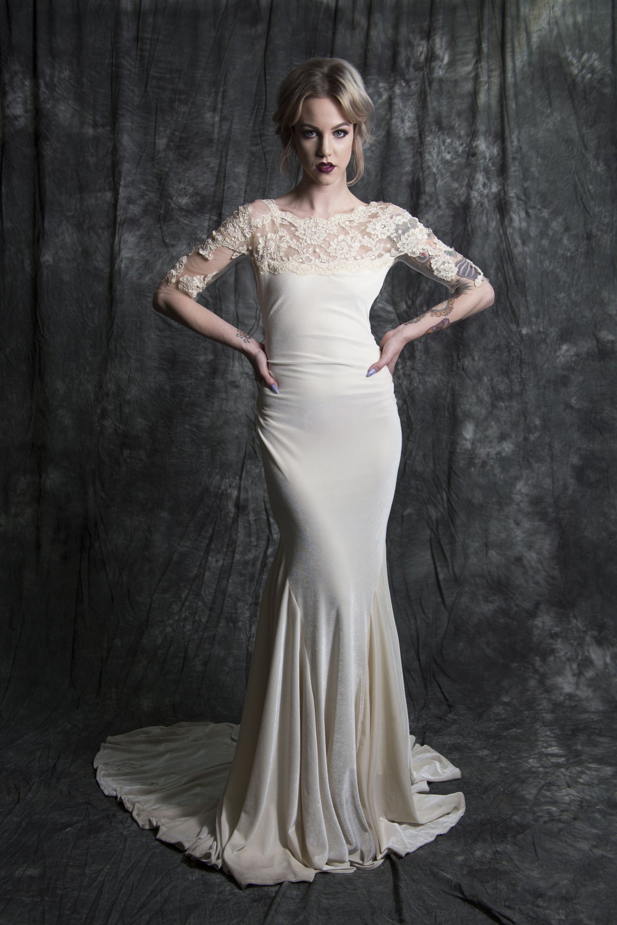 Elegant ivory mermaid wedding dress with lace sleeves and a flowing train, perfect for modern brides.