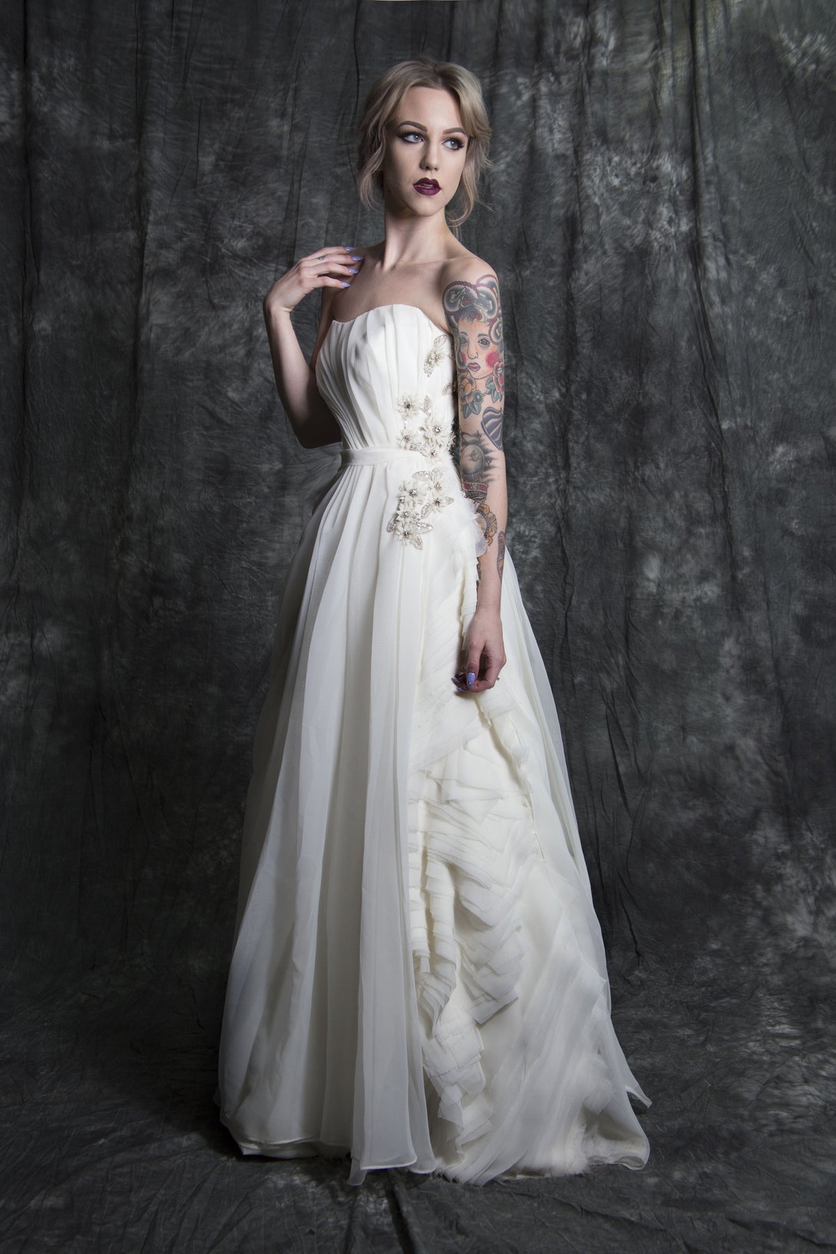 Elegant strapless wedding dress with floral embellishments and ruffled layers, perfect for unique bridal styles.