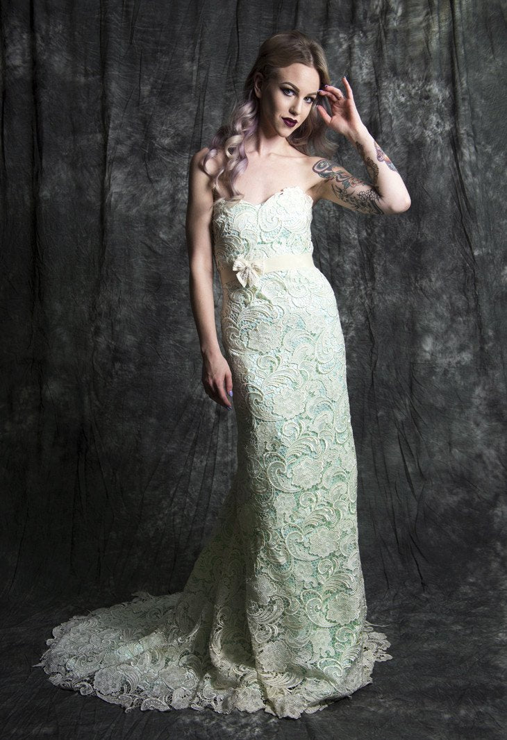 Elegant lace wedding dress with strapless design and flowing train, perfect for custom bridal looks.