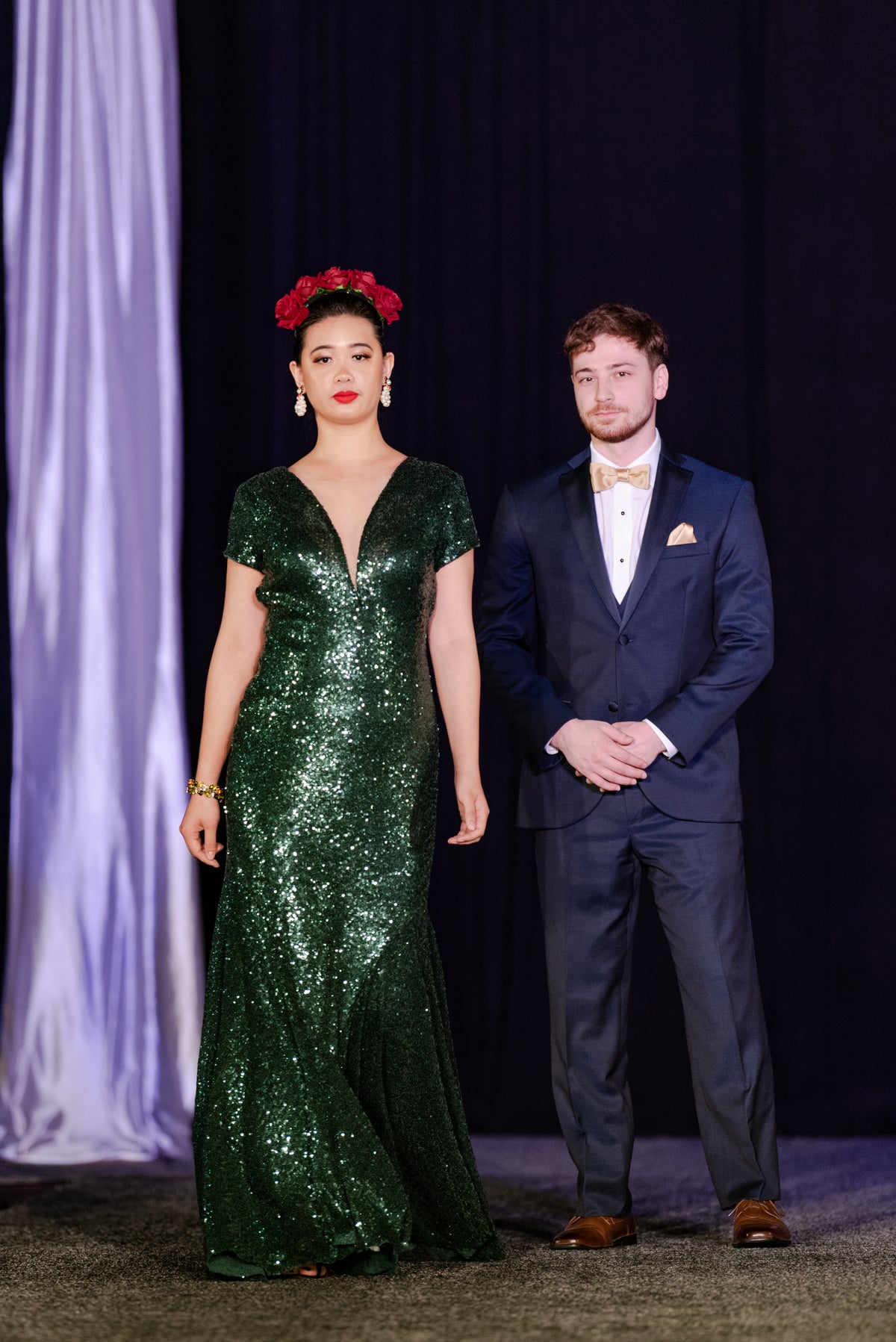 Emerald sequin wedding gown with V-neck, paired with navy tuxedo for modern bridal fashion