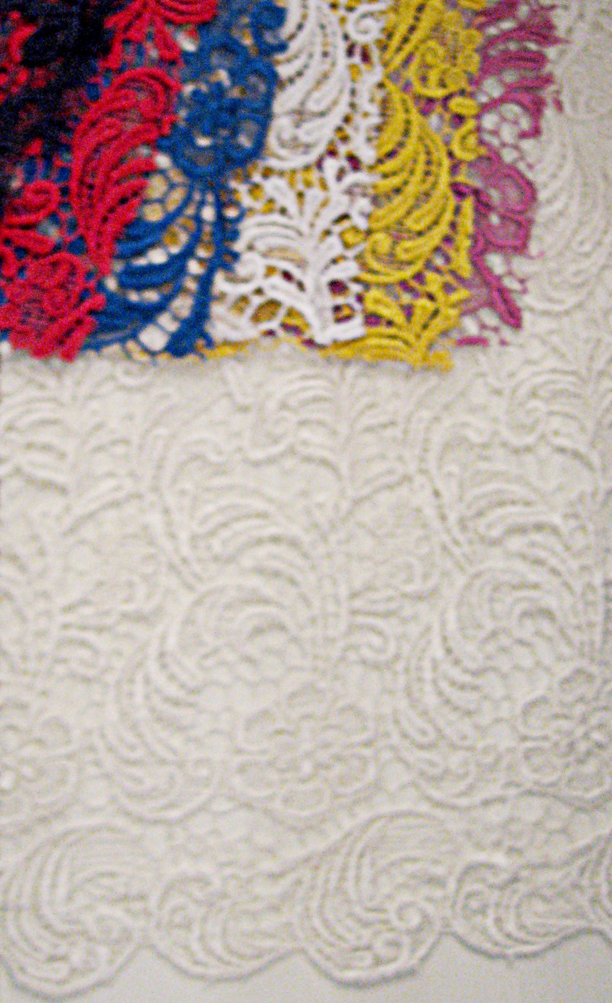 Colorful lace appliqués on white textured fabric for custom bridal designs