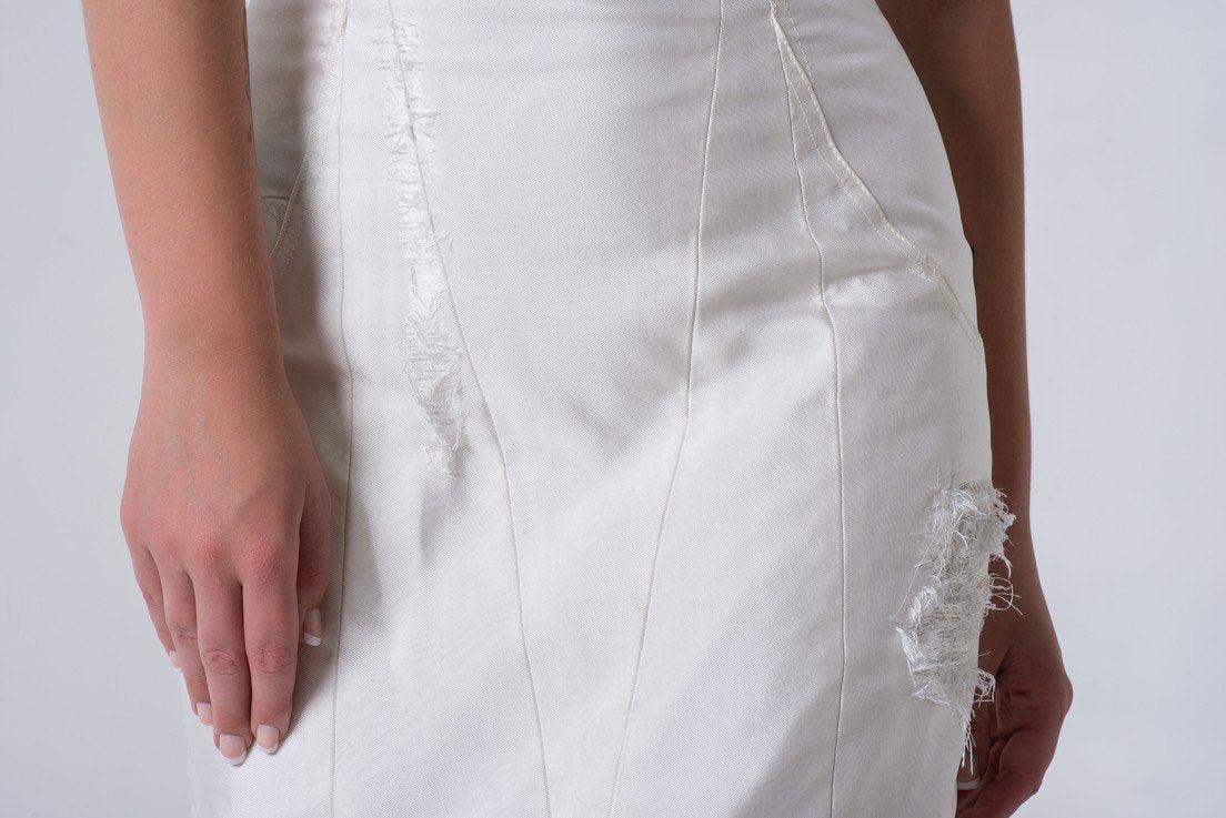 Custom white bridal dress with distressed details and sleek fit, showcasing unique texture and design.