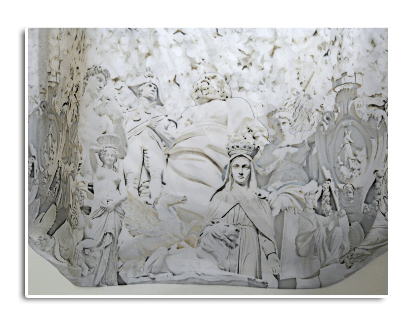 Intricate white bas-relief sculpture featuring crowned figures, angels, and classical motifs for wedding decor