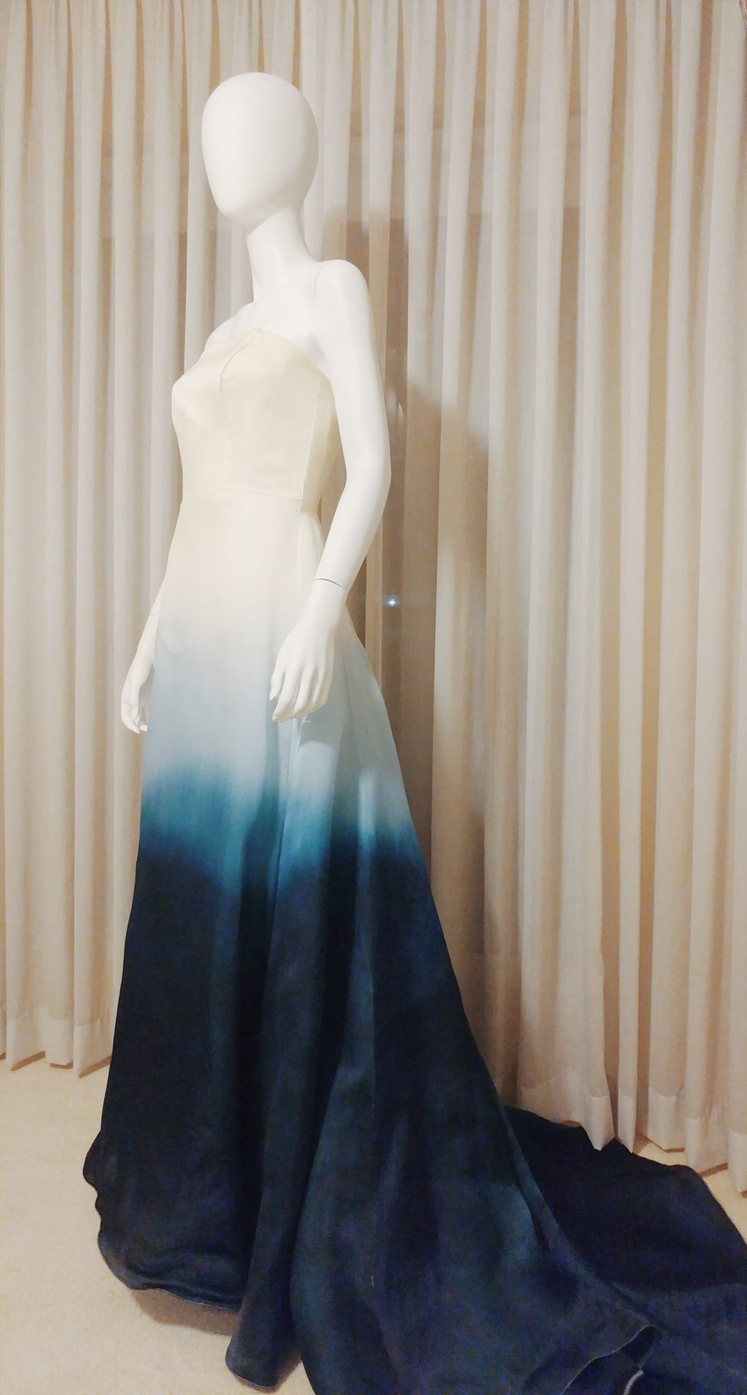 Custom ombre wedding dress with blue gradient dye, strapless design on mannequin